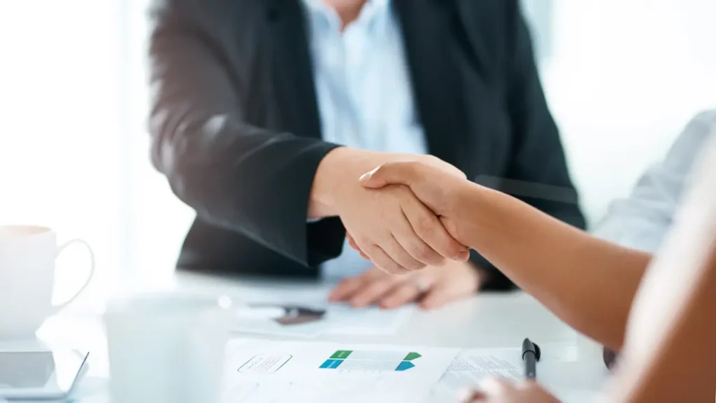 A funeral company staff and a client shaking hands to seal the deal