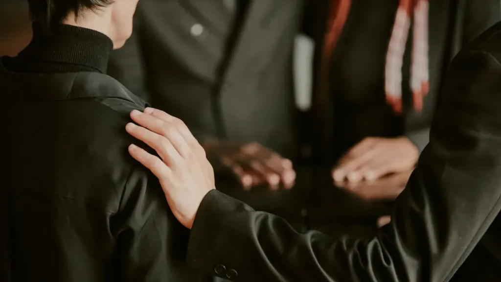 A hand on a shoulder to offer comfort and condolences