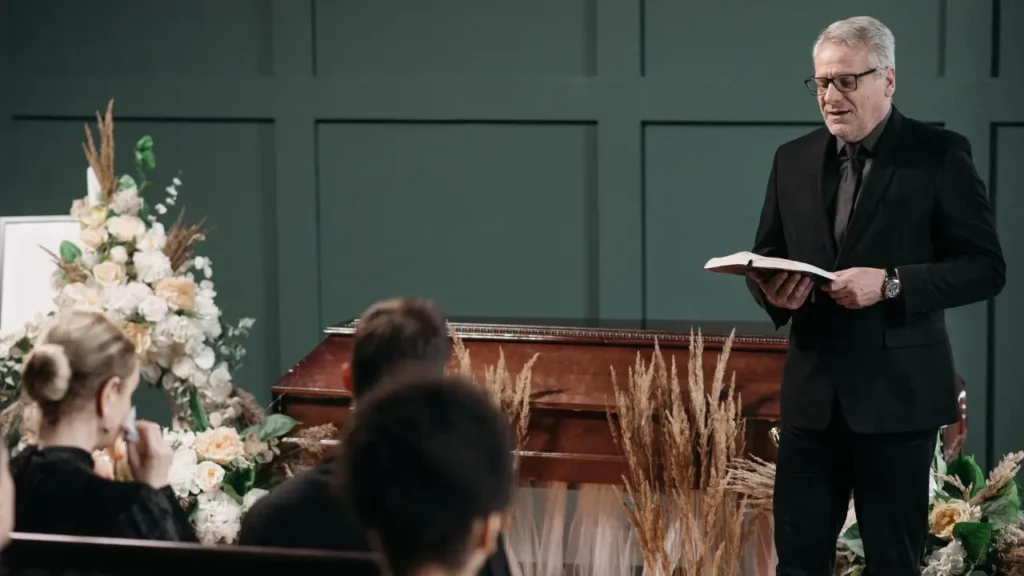 A priest leading a service during a funeral wake.