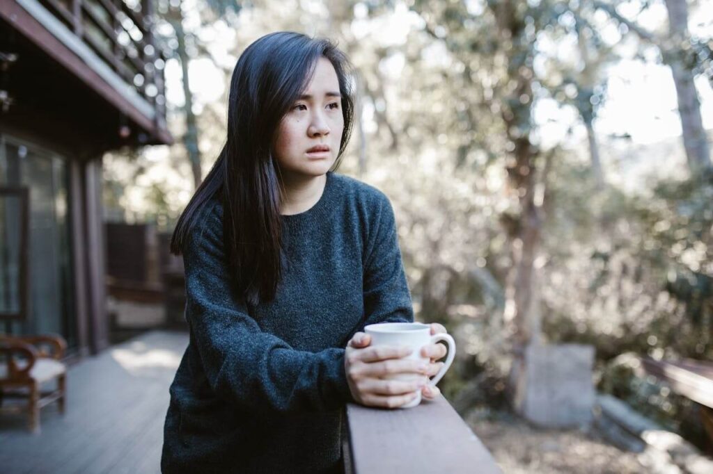 grieving woman holding a cup